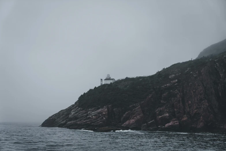 a lighthouse sitting on top of a hill next to a lake