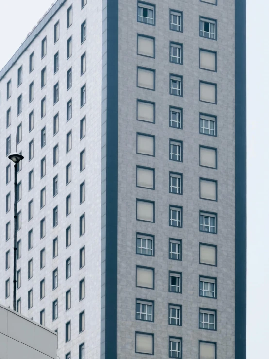 a large building with lots of windows next to a street light