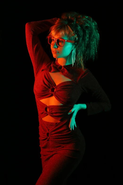 woman wearing glasses and a red dress poses