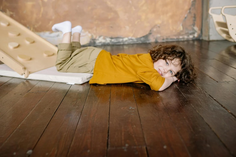 a woman in an orange shirt lying on the floor