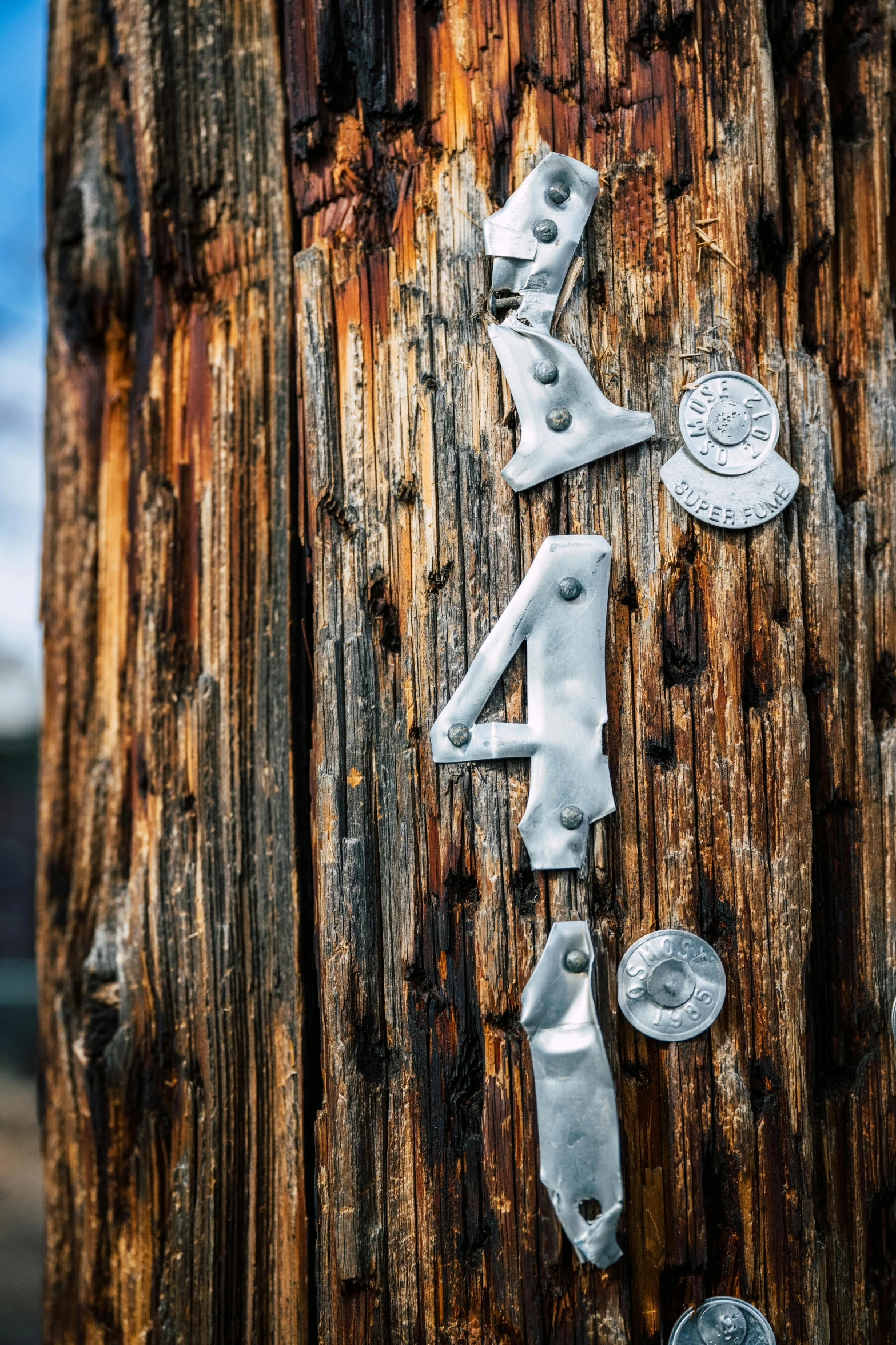 three old numbers are attached to the wooden post