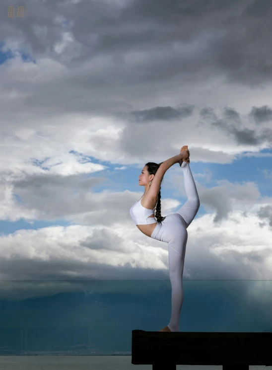 a woman wearing a white outfit doing yoga