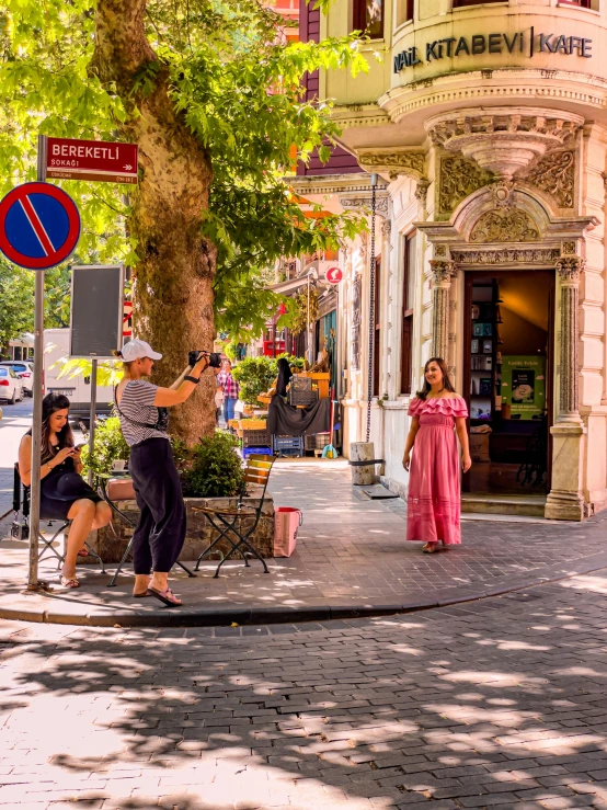 two women in pink are filming a street scene