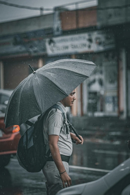 a man is walking down the sidewalk with an umbrella