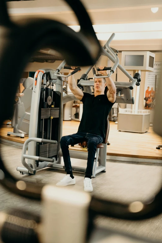 a man sitting in a gym bench holding a machine