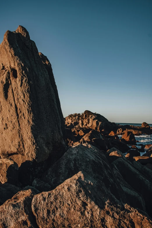 rocks with their faces sticking out of them on the shore