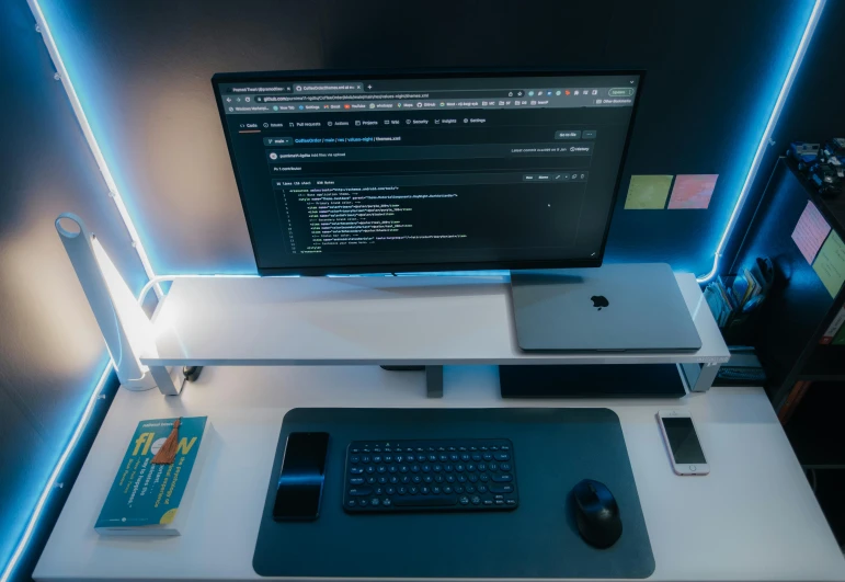 the computer is shown on a desk with various other items