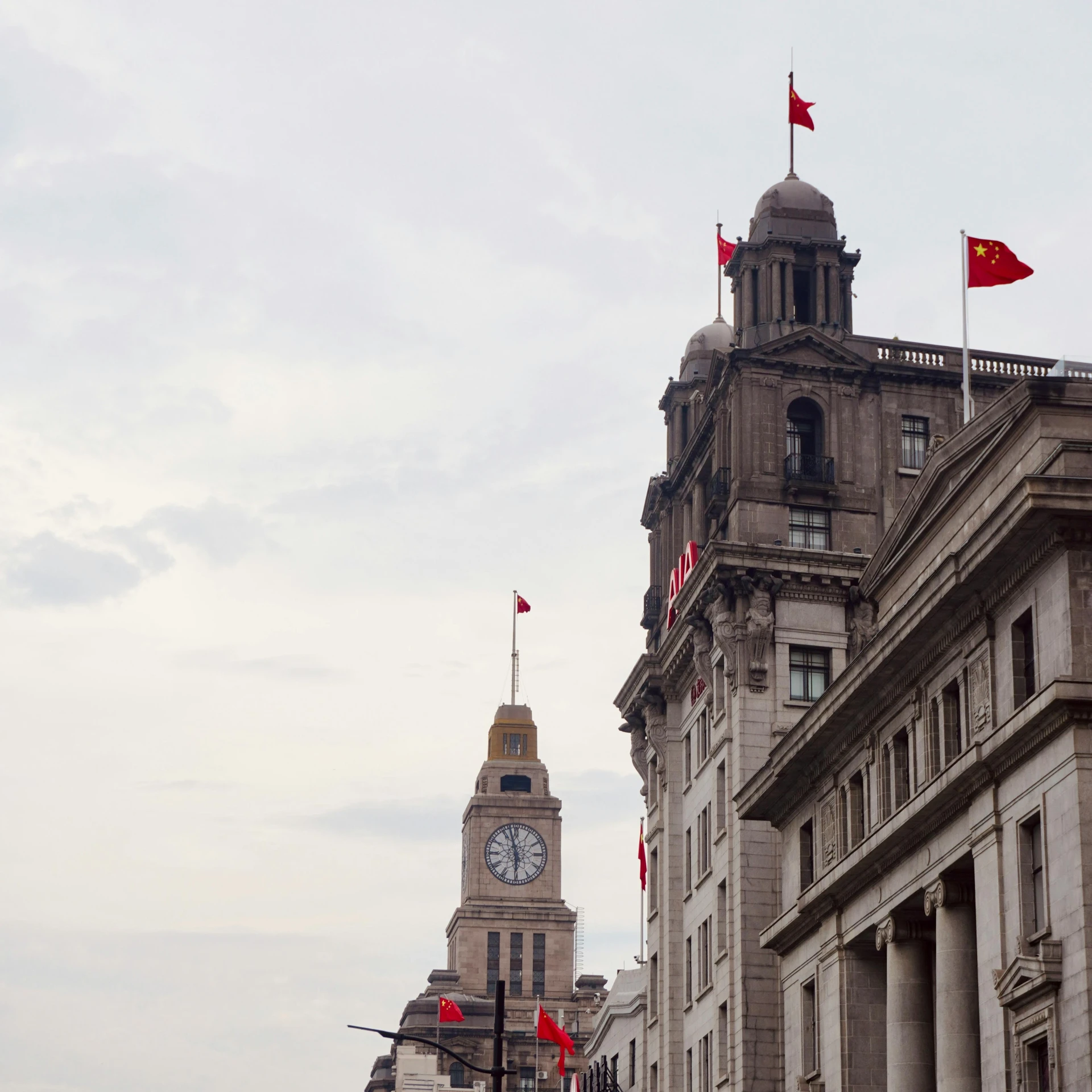 a building with a clock and flags on the outside