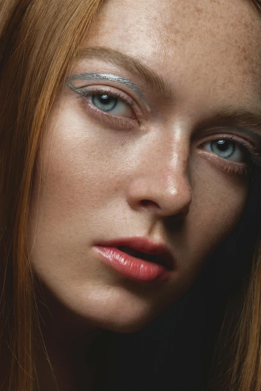 an artistic makeup s shows a model with blue eyes