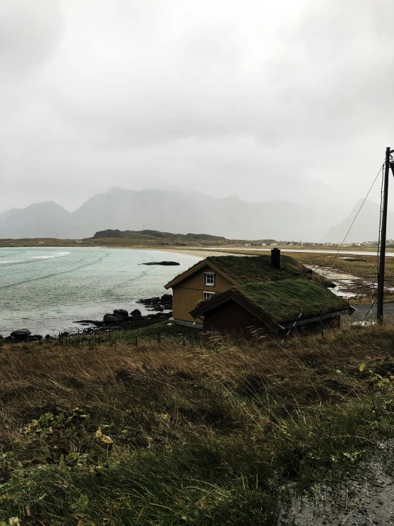 a house sits on the shore by the ocean