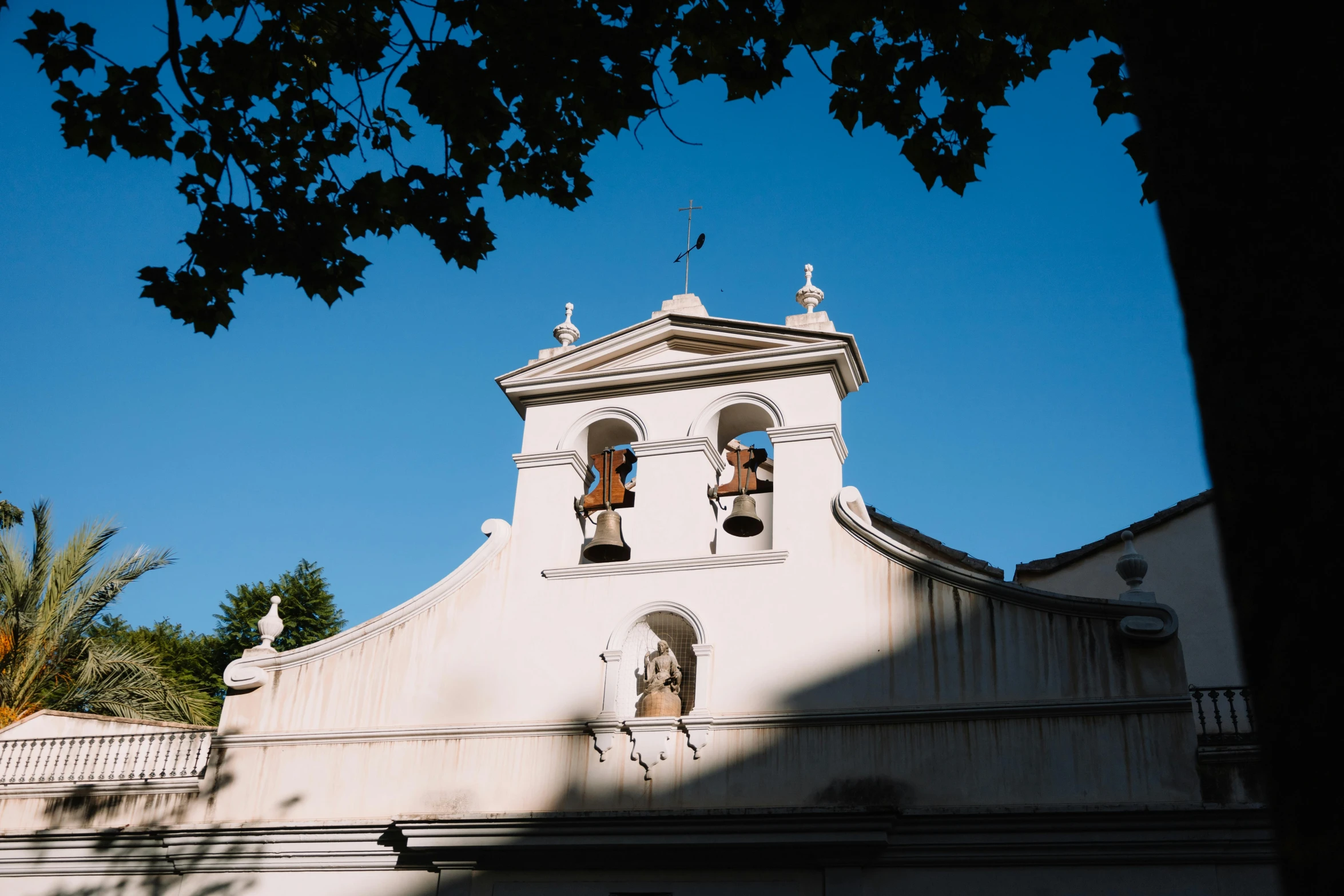 an old church steeple is silhouetted against a blue sky