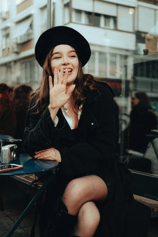 a woman sitting on a bench laughing at her phone