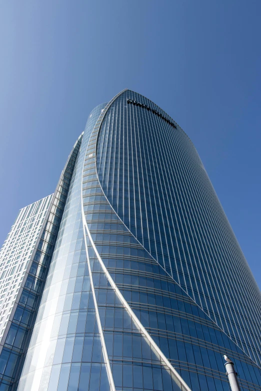 a tall building with lots of windows that have a blue sky behind it