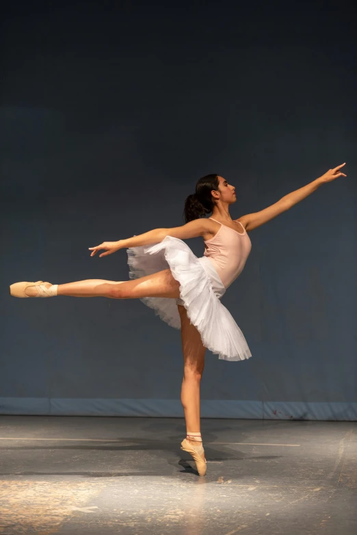 a female dancer in a white dress doing a split leg pose