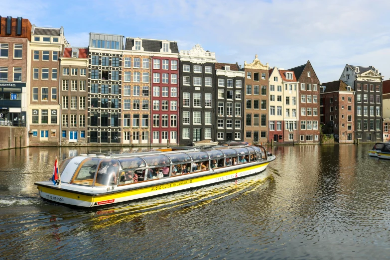 a long boat is moving on the water near buildings