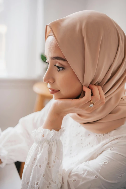 woman with hijab in white blouse looking away