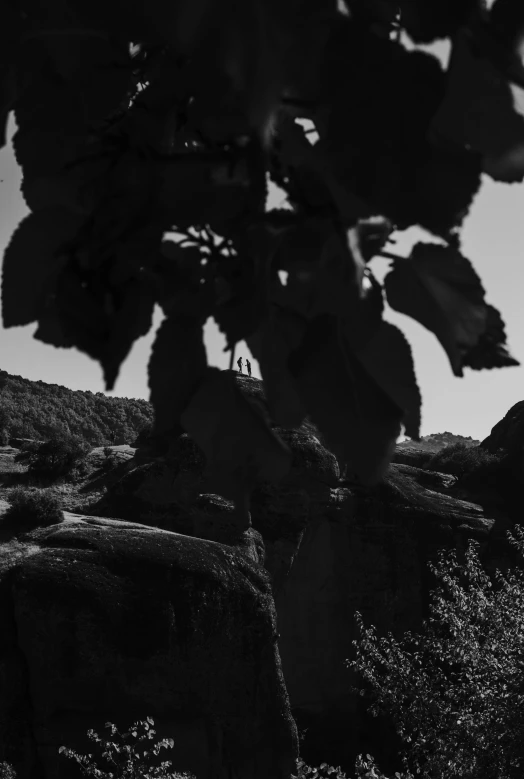 a large rock cliff with a person walking through it