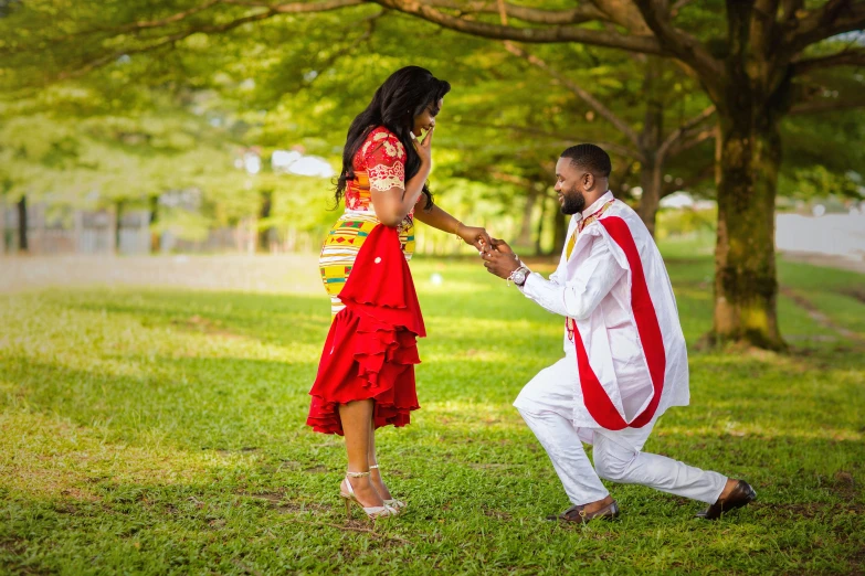 two people standing in a grassy field touching hands