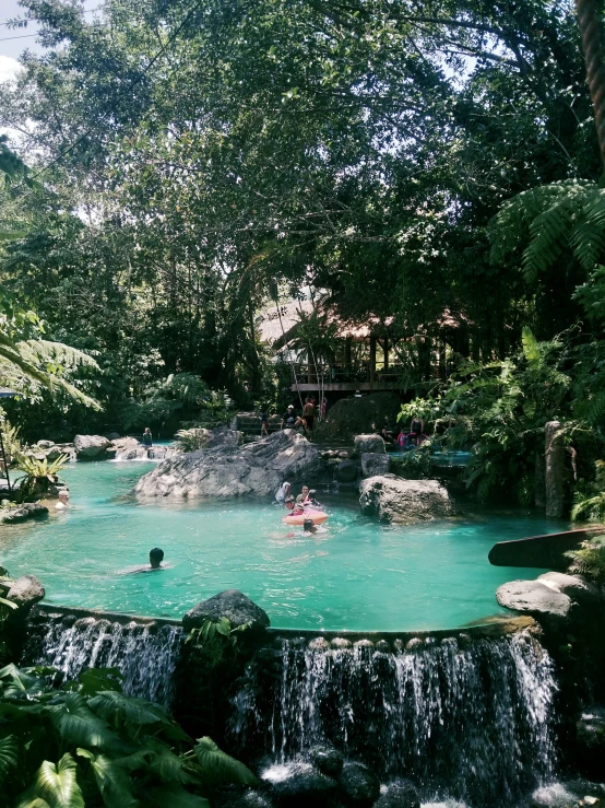 several people are in a small pond while others play around