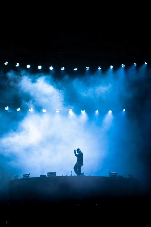 a person standing on top of a stage under lights