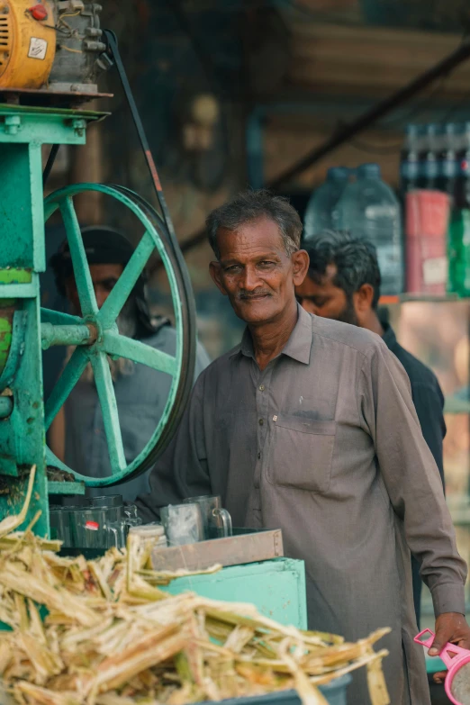 a man standing next to a machine holding some items