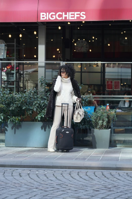 a woman is holding her suitcase outside a restaurant