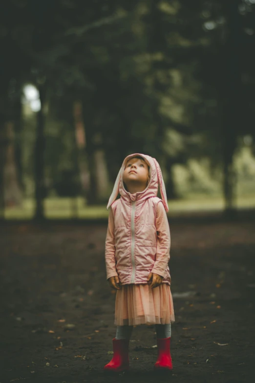 a little girl wearing boots, in a park