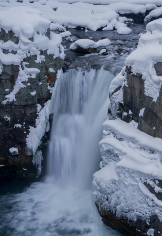 a very tall waterfall filled with lots of snow