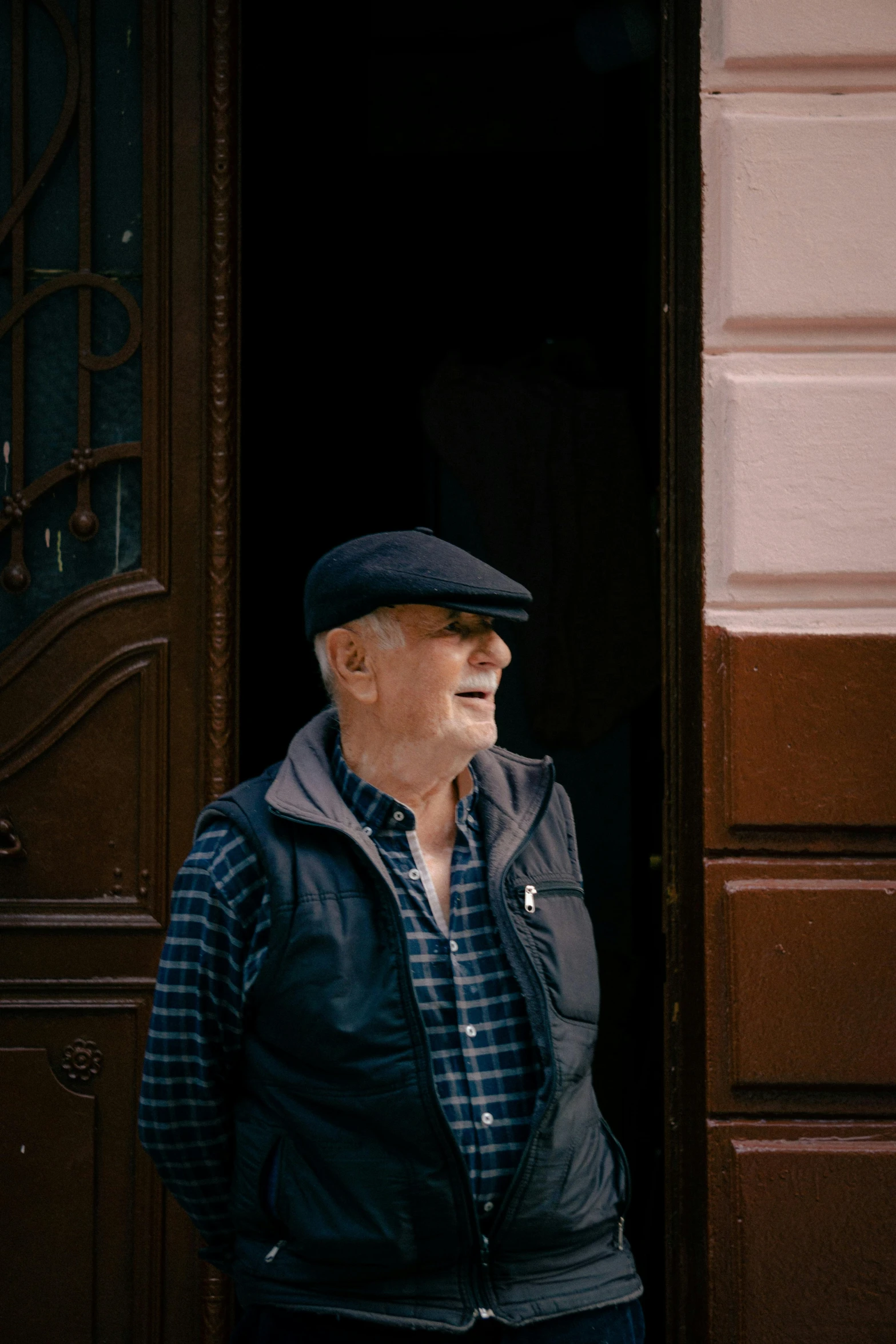 an older man stands in the doorway outside