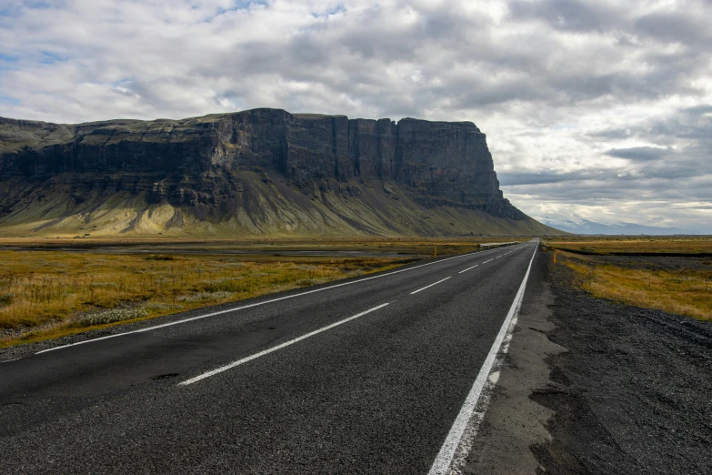 a view of an empty road and mountain in the distance