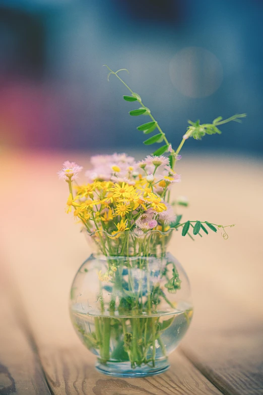 the flowers are in a glass vase sitting on a table