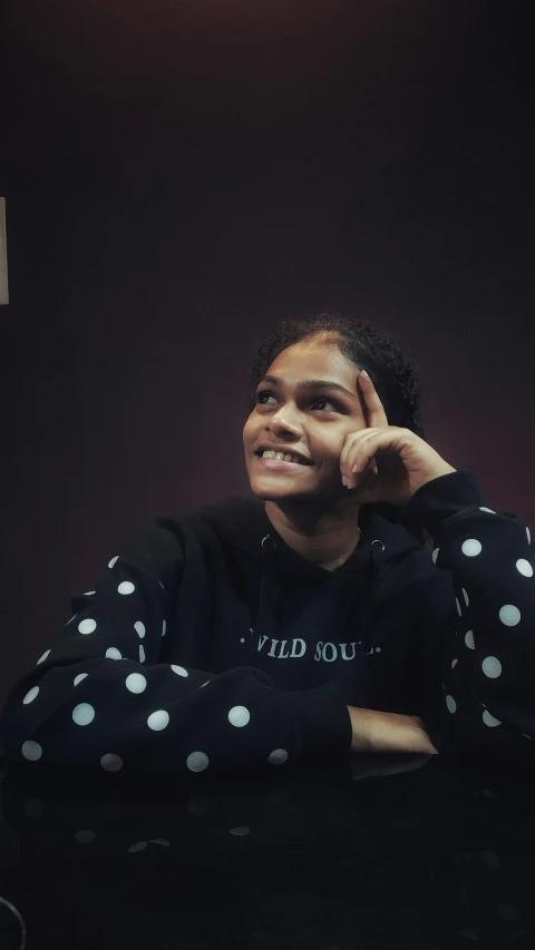 the young black woman smiles as she sits in a chair