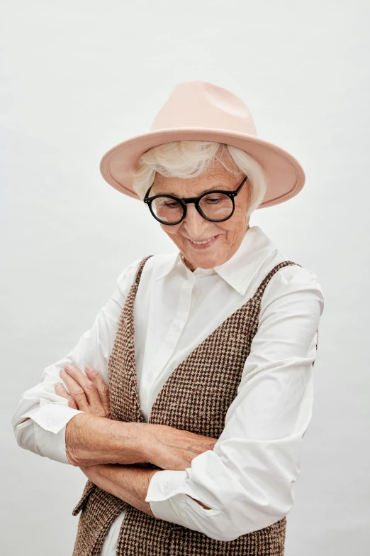 the old woman is wearing glasses, a hat and a vest