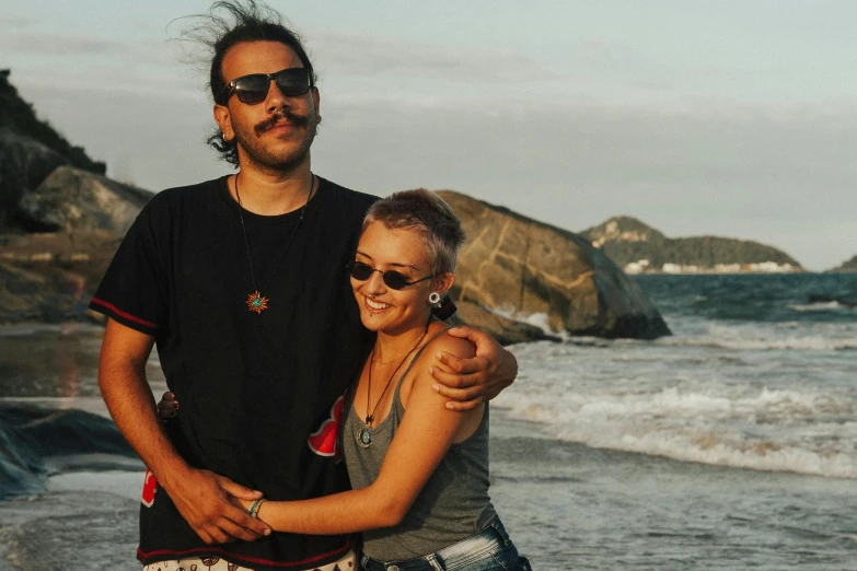 two people hugging on a beach with waves crashing over them