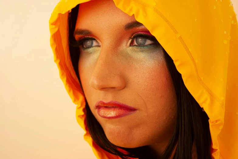 a woman with artistic makeup on her face wearing a raincoat