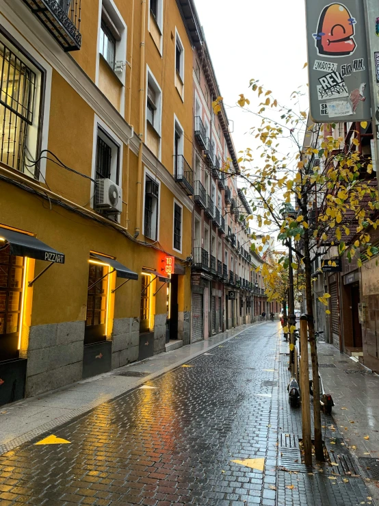 street scene with wet sidewalk and many buildings