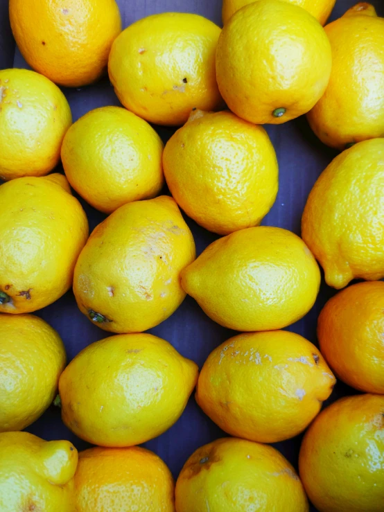 a bunch of lemons on display for sale in a bin
