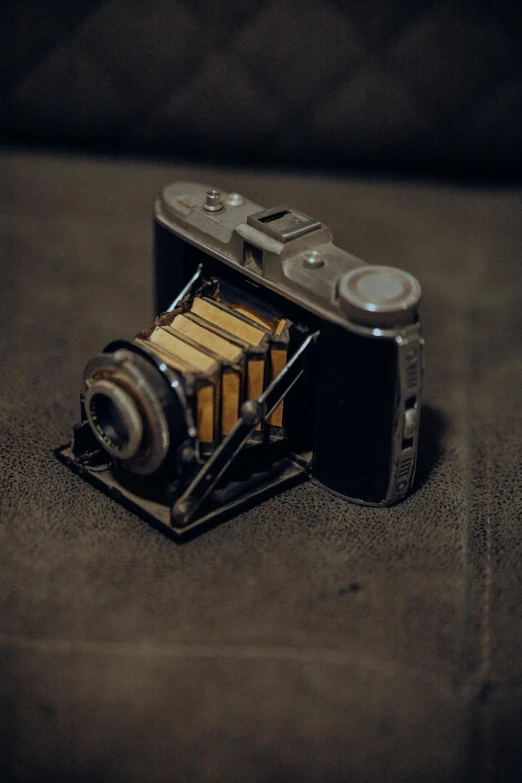 an old camera sitting on a table next to a bottle of oil