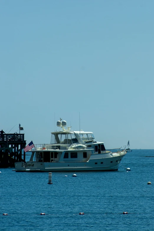 a boat is docked off a pier on the blue waters