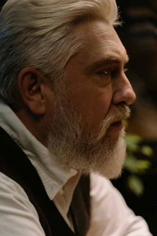 a man with a white beard wearing a vest