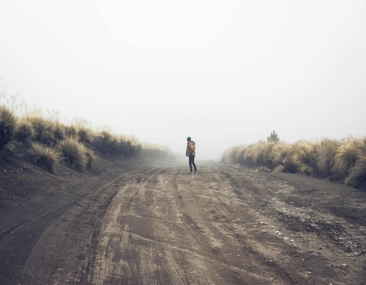 the road with two people standing on it is empty