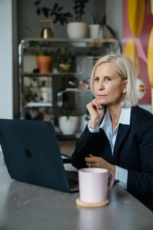 the woman is sitting at her desk looking at the computer