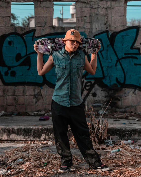 the young man is carrying his skateboard on his shoulders