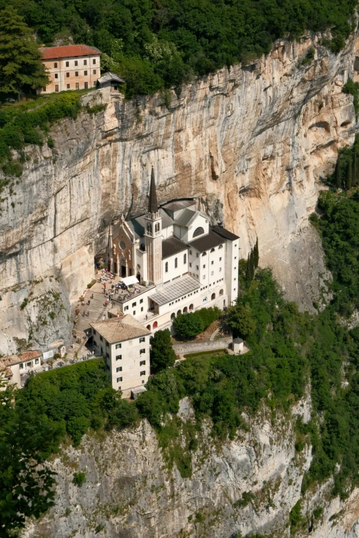an aerial view of an old, white building in a mountainous area