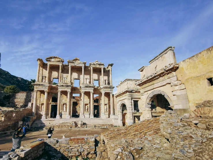 some people looking at the ruins of an old building