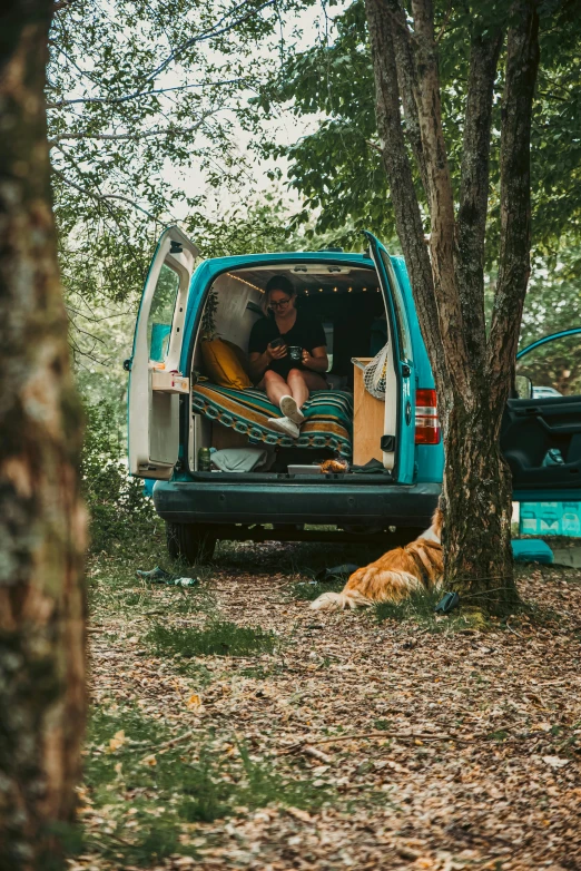 two people are in the back of a blue van