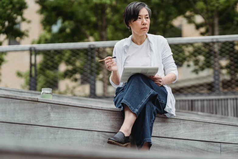 a woman with an electronic tablet sitting on the ledge