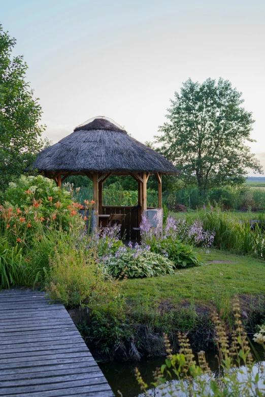 a gazebo in the middle of flowers and grass