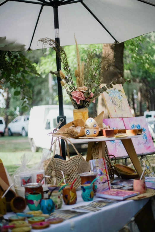 a table covered in books and decorations under an umbrella