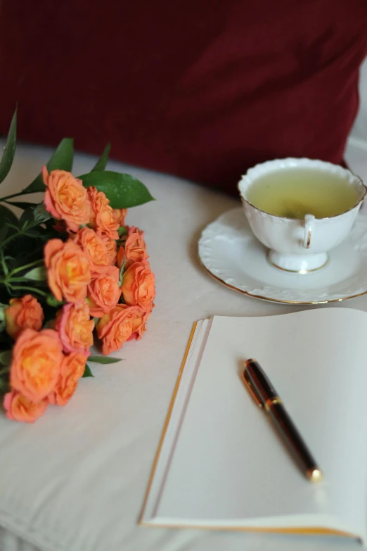 an arrangement of flowers and a book sit on the table